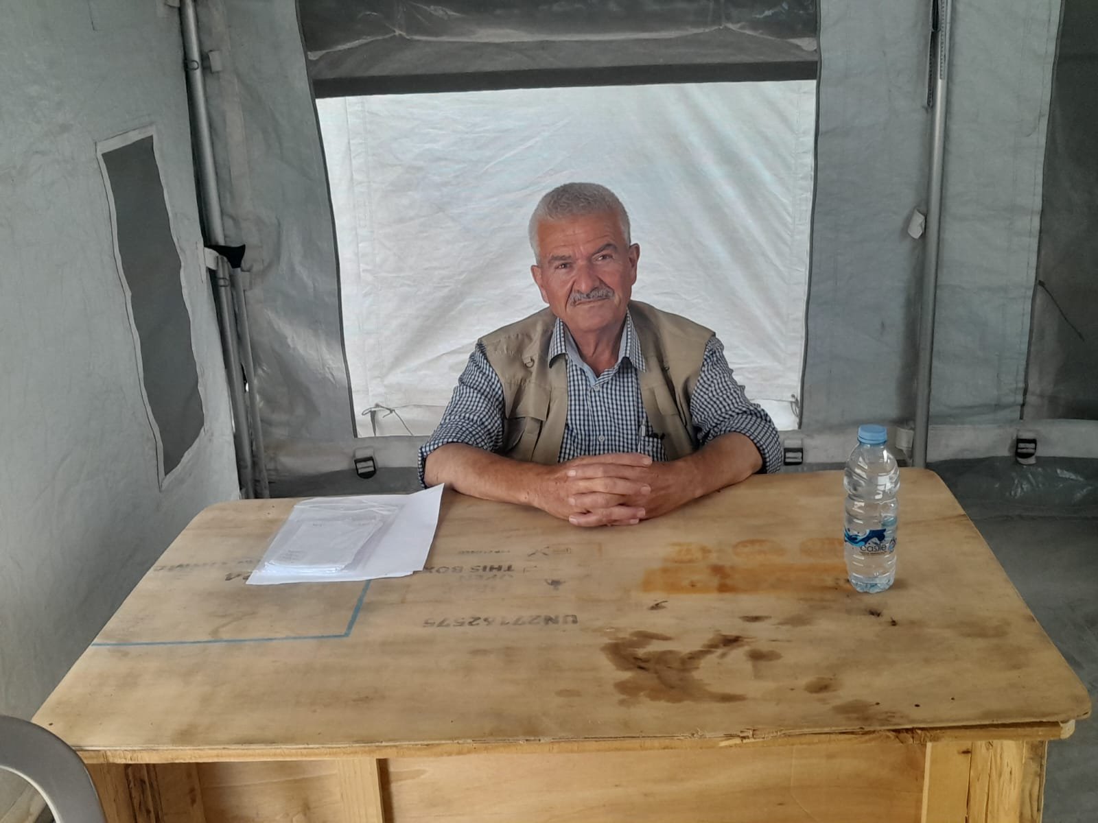 From the Ground Up: Building Al-Lababidi Clinic in Gaza Staff member seated at a desk inside a clinic tent