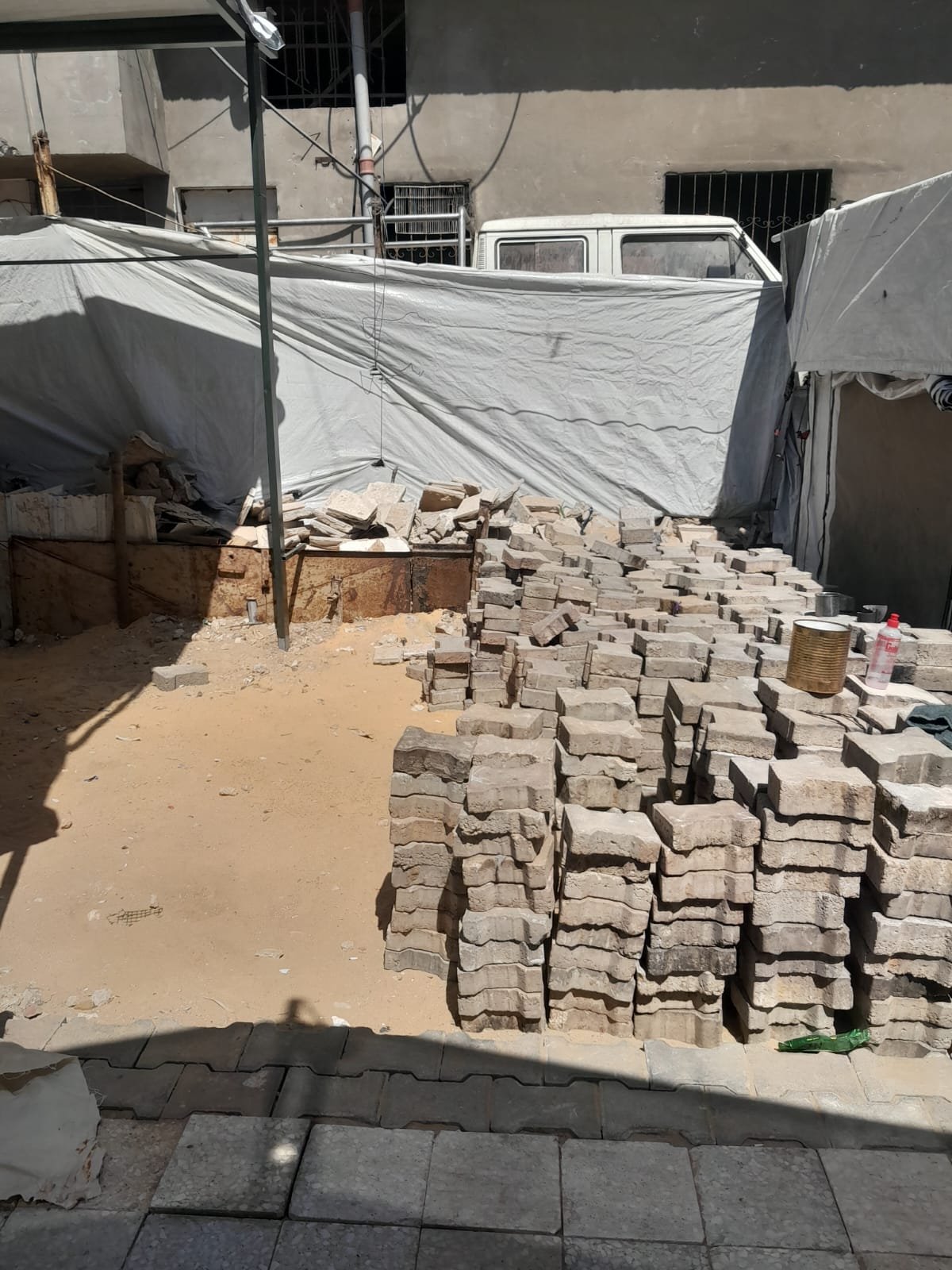 From the Ground Up: Building Al-Lababidi Clinic in Gaza Paving blocks stacked beside a partially paved route between clinic tents